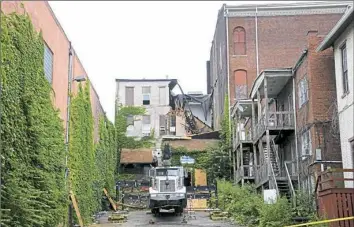  ?? Lake Fong/Post-Gazette ?? The remains of the three-story building on North Main Street in Washington, Pa., that collapsed Wednesday morning, trapping a woman.