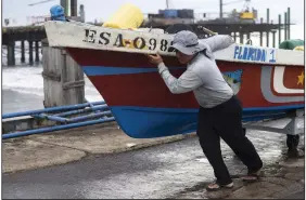  ?? (AP/Moises Castillo) ?? A fisherman secures a boat, preparing for the arrival of Hurricane Julia Sunday in La Libertad, El
Salvador.