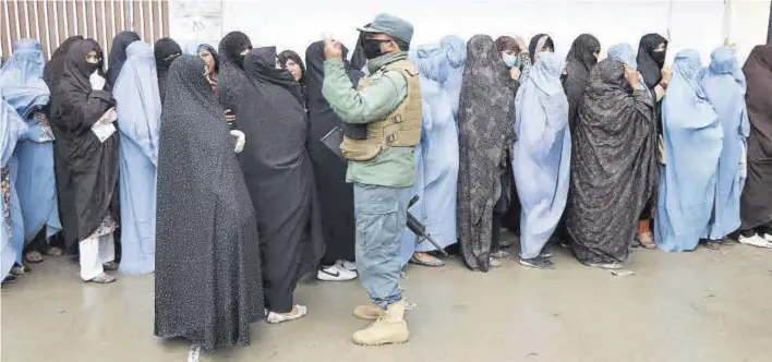  ?? JALIL REZAYEE / EFE ?? Mujeres afganas hacen fila para recibir una ración gratuita de comida distribuid­a por el Programa Mundial de Alimentos, en Herat.