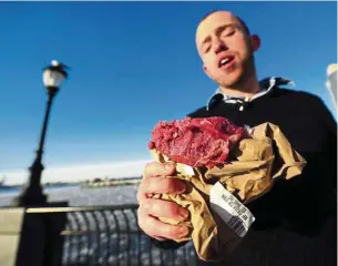  ??  ?? This file photo shows ‘caveman’ Vlad Averbukh, 29, a follower of the Paleo diet, eating raw meat along the Hudson River in New York. Followers of the Paleo diet enjoy a Stone Age cavemen fare of what could be found in nature.