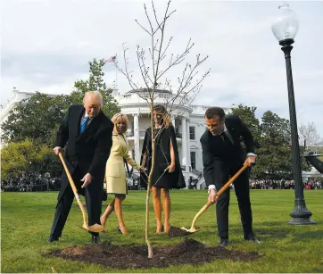  ?? PHOTO AFP ?? Hier, sous le regard de leurs épouses, Donald Trump et Emmanuel Macron ont planté un jeune chêne, cadeau du président français, dans la cour de la Maison-Blanche.