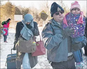  ?? CP PHOTO ?? An RCMP officer escorts a woman and a child claiming to be from Yemen as they cross the U.S.-Canada border in Hemmingfor­d, Que., Sunday. Federal cabinet ministers are set for an in-depth discussion this week of the practical and political pressures...