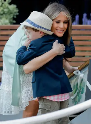  ?? AP ?? First lady Melania Trump is hugged by Noah Haas, 7, of Annapolis, Maryland, who presented her with a gift, at the opening of the Bunny Mellon Healing garden in Washington. —