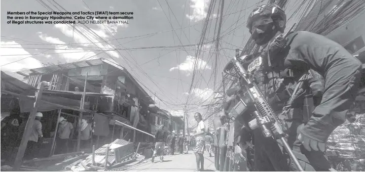  ?? ALDO NELBERT BANAYNAL ?? Members of the Special Weapons and Tactics (SWAT) team secure the area in Barangay Hipodromo, Cebu City where a demolition of illegal structures was conducted.