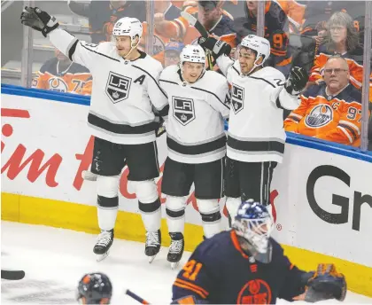  ?? GREG SOUTHAM ?? From left, the Kings' Dustin Brown, Blake Lizotte and Andreas Athanasiou celebrate a goal on Oilers goalie Mike Smith Tuesday during Game 5.