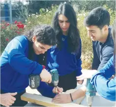  ?? (Yeshiva University) ?? YESHIVA UNIVERSITY students Nora Shokrian, Shanee Carmel and Orley Bral build picnic tables in Halamish where the wooden tables and benches in the public parks were consumed by wildfires in November.