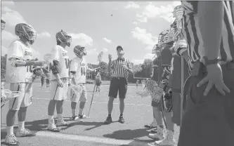  ?? COURANT FILE PHOTO ?? REFEREE Ted Murphy tosses the coin before the start of a lacrosse game between Southingto­n and Simsbury in 2013. High school officials are aging and the CIAC has been amping up efforts to recruit younger candidates.