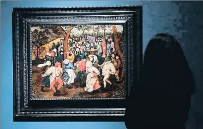  ?? EMILIA GUTIÉRREZ ?? Una visitant admira el quadre Ball de casament camperol a l’aire lliure, de Pieter Bruegel el Jove