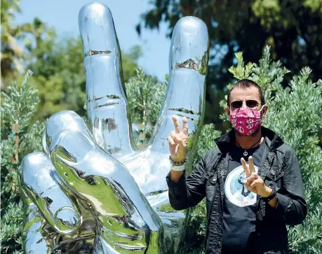  ?? ?? Simboli
L’ex Beatles Ringo Starr, 81 anni, batterista, posa accanto alla scultura «Peace and Love» che si trova nel parco di Beverly Hills, in California