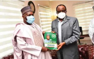  ??  ?? Governor Muhammadu Inuwa Yahaya presenting a publicatio­n containing some of his achievemen­ts in one year to the Managing Director, North East Developmen­t Commission , Mohammed Goni Alkali