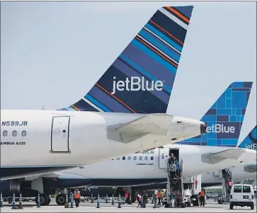  ?? Patrick T. Fallon Bloomberg ?? LONG BEACH Airport forced JetBlue Airways to give up nearly a third of its gate slots about a year ago.