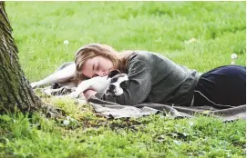  ?? PAM PANCHAK/ASSOCIATED PRESS ?? A woman and her dog nap between rain showers at Schenley Park, Tuesday, May 4, 2021 in Pittsburgh. The Gallup survey, released Monday, April 15, 2024, says that a majority of Americans say they would feel better if they could have more sleep.