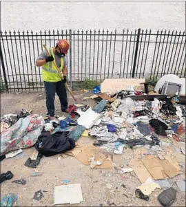  ?? Irfan Khan Los Angeles Times ?? ERIC ALVARADO of a Los Angeles sanitation crew cleans an alley behind the 700 block of 107th Street that is littered with illegally dumped trash in 2015.