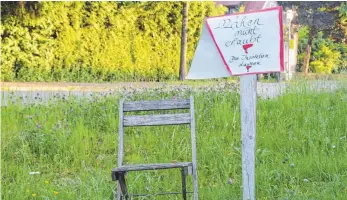  ?? FOTO: SEBASTIAN HEILEMANN ?? Schon mehr als eine Woche verhindern Klappstuhl und Protestpla­kat die Mäharbeite­n auf dem Grünstreif­en in der Ravensburg­er Straße.