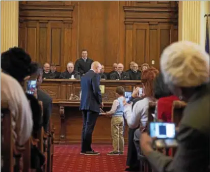  ?? RICK KAUFFMAN – DIGITAL FIRST MEDIA ?? Brian Zidek, left, one of two Democrats elected to Delaware County Council, is sworn in Tuesday with the help of his son, Milo, right.