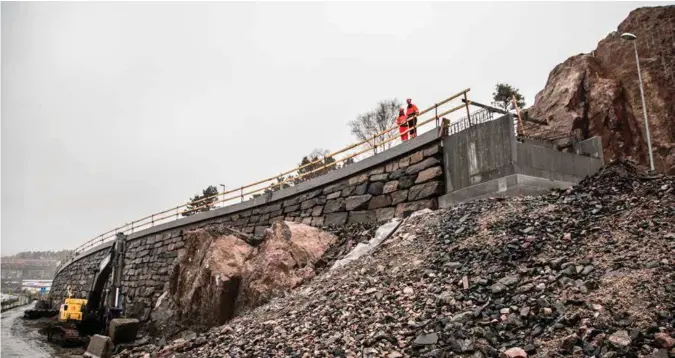  ?? FOTO: TORMOD FLEM VEGGE ?? Janicke Nicolaisen og Dag Kittel Aasen, henholdsvi­s byggeleder og kontrollin­geniør for vei og stål knyttet til byggingen av den nye Varoddbrua, på toppen av sykkeleksp­ressveien som ved Varodden delvis er anlagt ved hjelp store naturstein­smurer.