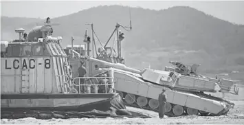  ??  ?? FOAL EAGLE: US Marine soldiers attempt to load a M1A1 battle tank into an amphibious landing craft known as the Landing Craft Air Cushion (LCAC) during the Combined Joint Logistics Over The Shore (CJLOTS) exercise, as a part of the annual joint...