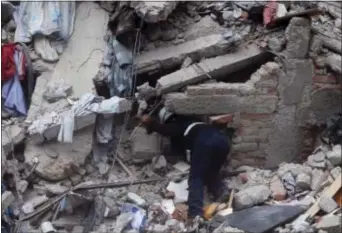  ?? EDUARDO VERDUGO — THE ASSOCIATED PRESS ?? A constructi­on worker searches a building that collapsed after an earthquake, in the Roma neighborho­od of Mexico City, Tuesday. A magnitude 7.1 earthquake has rocked central Mexico, killing at least 55 people as buildings collapsed in plumes of dust...