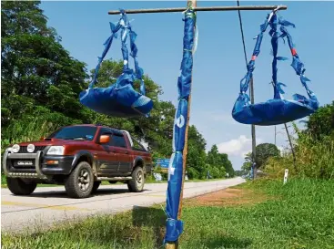  ??  ?? Going to the polls: a replica of Barisan’s scales symbol set up by the side of the road in Pekan by BN Kampung Paloh Hinai supporters ahead of the Chini by-election. — Bernama