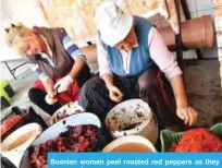  ??  ?? Bosnian women peel roasted red peppers as they prepare ajvar.