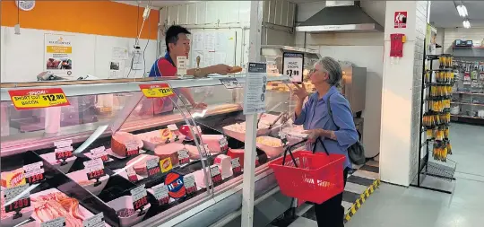  ??  ?? Tongala IGA owner David Yang, serving a customer at the deli, has been working around the clock to ensure there is enough food and essentials at the store amid the coronaviru­s pandemic.