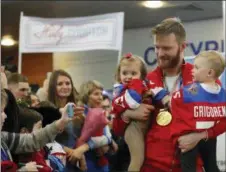  ?? PAVEL GOLOVKIN — THE ASSOCIATED PRESS ?? Russian ice hockey player Mikhail Grigorenko holds his children as he arrives at Sheremetye­vo airport, outside Moscow Monday.