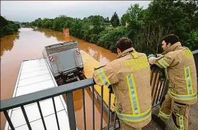  ??  ?? Dálnice. Hasiči z města Pulheim nedaleko Kolína nad Rýnem shlížejí z nadjezdu na zcela zaplavenou dálnici číslo 265. Foto: Profimedia