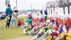  ?? ERIC GAY/ASSOCIATED PRESS ?? Christina Osborn and her children, Alexander Osborn and Bella Araiza, visit a makeshift memorial Sunday for the victims of the Nov. 5 shooting at Sutherland Springs Baptist Church in Sutherland Springs, Texas.