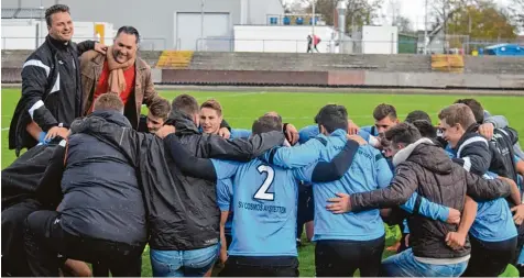  ?? Foto: Oliver Reiser ?? Zusammen mit der Mannschaft und dem Betreuerte­am feierten Trainer Marco Löring und Vereinsvor­sitzender Thomas Pflüger (von rechts) im strömenden Regen den 2:0 Sieg des SV Cosmos Aystetten bei Türksport Augsburg.