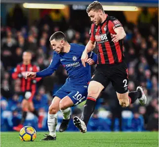  ??  ?? Out of my way: Chelsea midfielder Eden Hazard (left) vying for the ball with Bournemout­h defender Simon Francis during the English Premier League match at Stamford Bridge on Wednesday, — AFP