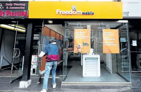  ?? THE CANADIAN PRESS FILES ?? A man enters a Freedom Mobile store in Toronto in 2016.