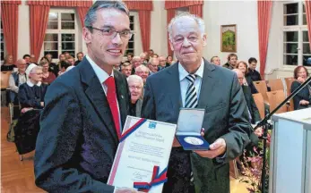  ?? FOTO: THOMAS SIEDLER ?? Ein Mann mit dem Mut zu musikalisc­hen Wagnissen: Willibald Bezler (rechts) ist im Palais Adelmann von Oberbürger­meister Karl Hilsenbek mit der Bürgermeda­ille geehrt worden.