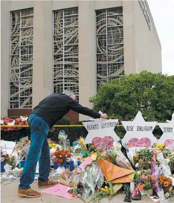  ?? PHOTO AFP ?? Un proche des victimes s’est recueilli devant le monument de fortune érigé devant la synagogue Tree of Life où le tueur a abattu onze fidèles en plein office samedi.