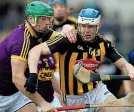  ??  ?? Aim: TJ Reid holds off Matthew O’Hanlon of Wexford INPHO