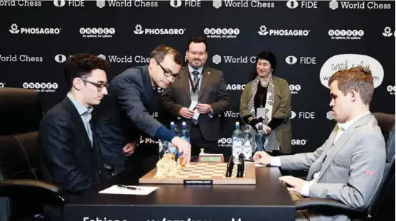  ?? FOTO: NADJA PANTELEJEV­A, WORLD CHESS ?? Her gjør Demis Hassabis det seremoniel­le første trekket i VM-parti 8. Hassabis er administre­rende direktør i Google-eide Deepmind, som utvikler programmet AlphaZero.