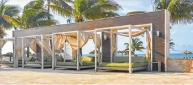  ?? PHOTOS BY ANNE BRALY ?? Poolside beds offer a good deal more comfort than a lounge chair on the beach at Wyndham Fortuna in the Bahamas, above. At left, guests take a siesta in the shade of a large palm at Sandals Emerald Bay.