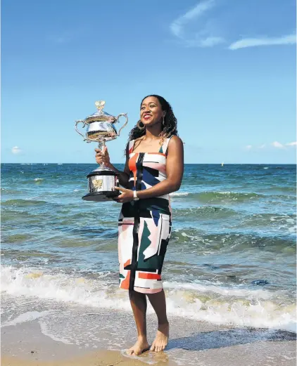  ?? PHOTO: GETTY IMAGES ?? Career at high tide . . . Australian Open champion Naomi Osaka, of Japan, poses with the Daphne Akhurst Memorial Cup at Brighton Beach in Melbourne yesterday. Osaka beat Petra Kvitova, of the Czech Republic, 76 (72), 57, 64 in the women’s final on Saturday night.