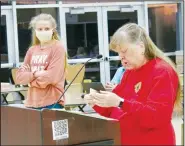  ?? (NWA Democrat-Gazette/Susan Holland) ?? Piper Batie, an eighth-grader at Gravette Middle School, listens Feb. 22 as Linda Damron, Gravette Lions Club president, tells about her winning poster in the Lions Club Internatio­nal Peace Poster Contest. Batie was honored at the Gravette School Board meeting for winning first place in the Gravette contest and second place in district competitio­n with her poster on the theme “Peace through Service.”