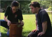  ?? RICHARD PAYERCHIN — THE MORNING JOURNAL ?? Jacob Rau of South Amherst and Lorain County Metro Parks Aide Emily Dunegan peer inside the ice cream maker on July 15, at the Benjamin Bacon House at the Vermilion River Reservatio­n.