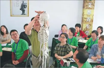  ??  ?? Cao Zhongbing, a teacher at Hubei Polytechni­c University in Huangshi, Hubei province, shows students how to do moxibustio­n.