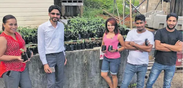  ??  ?? Touch Wood Fiji director Imaar Qamer, second from left, with chillie plants which will be distribute­d to families in Deuba.