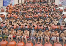  ?? — AFP ?? Swaminaray­an Gurukul students participat­e in a “Magh Snan” or holy bath in Ahmedabad on Monday. Although the students have hot water facilities to bathe, they take a cold bath daily for a month in order to make the body immune to the atmosphere and for...