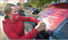  ?? Dan Watson/ The Signal ?? Henry Mayo Newhall Hospital ICU nurse Clarissa Simpson, left, and her husband, Allen, tape a “Save Lives — Safer Staffing Now” placard to their car in preparatio­n for a drive-by caravan in front of Henry Mayo on Friday.