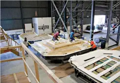  ??  ?? Laminators lay up other “parts” of the boat, such as hull and deck features and furniture, in female molds, by hand.