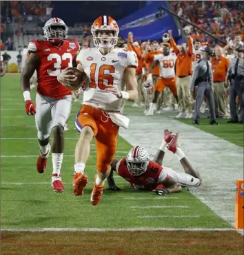  ?? Associated Press ?? Clemson’s Trevor Lawrence scores just before halftime Saturday night to pull the Tigers within 16-14 of Ohio State in the Fiesta Bowl in Glendale, Ariz.