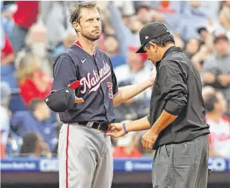  ?? USA TODAY ?? Max Scherzer of the Washington Nationals, left, allows the umpire to check his hat and belt for foreign substances. Scherzer was checked three times in four innings for substances and nothing was found.