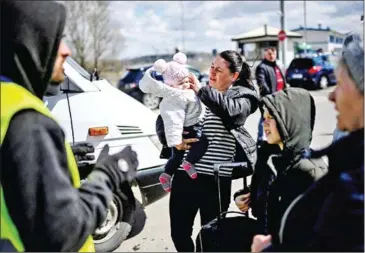  ?? AFP ?? A Ukrainian refugee holds her baby before boarding a minibus taking them further inside Moldova after crossing the Ukrainian-Moldovan border into Moldova at the Palanca border crossing, southeaste­rn Moldova on April 12.