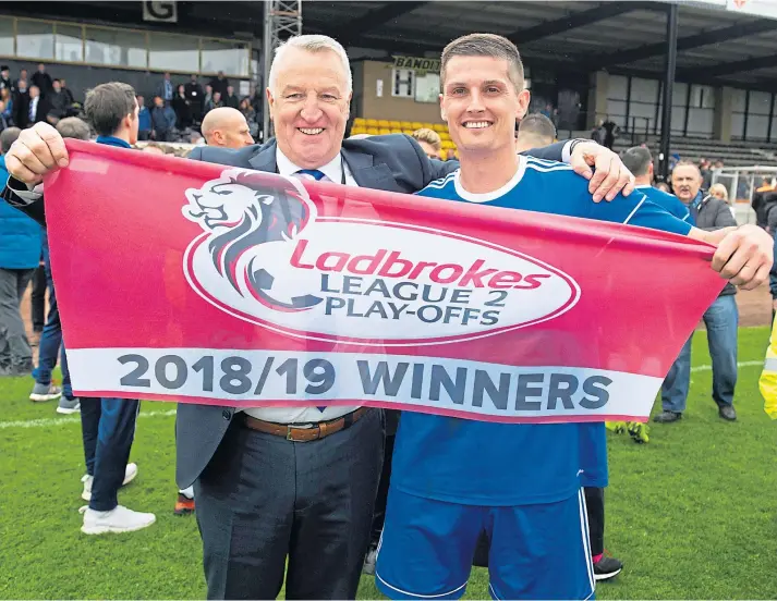  ??  ?? WINNERS: Cove co-manager John Sheran, left, celebrates his side’s promotion to the SPFL ranks on Saturday alongside Daniel Park