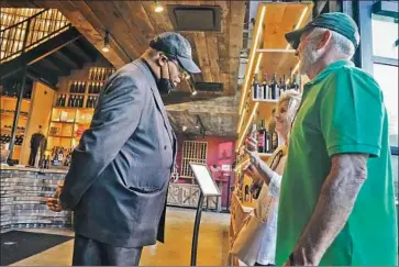  ?? Frank Franklin II Associated Press ?? A SECURITY officer asks customers for proof of vaccinatio­n at City Winery in New York City on Thursday. Across the U.S., many businesses have been reluctant to demand proof of COVID inoculatio­n from patrons.