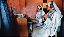  ??  ?? Rafaela (left) and Fatimam, fellow nuns of Maria Valentina de los Angeles make an internet radio program at a convent.